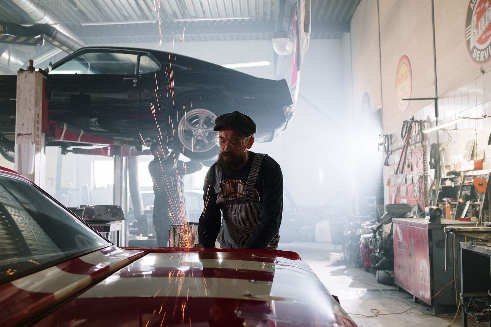 Technician performing bodywork with grinding sparks in an auto body shop