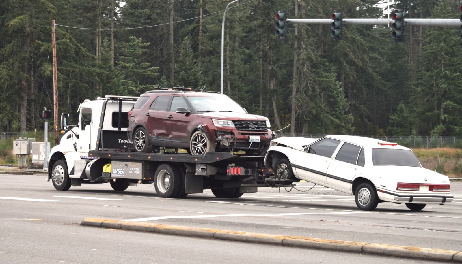 Flatbed tow truck recovering vehicles after a roadside incident
